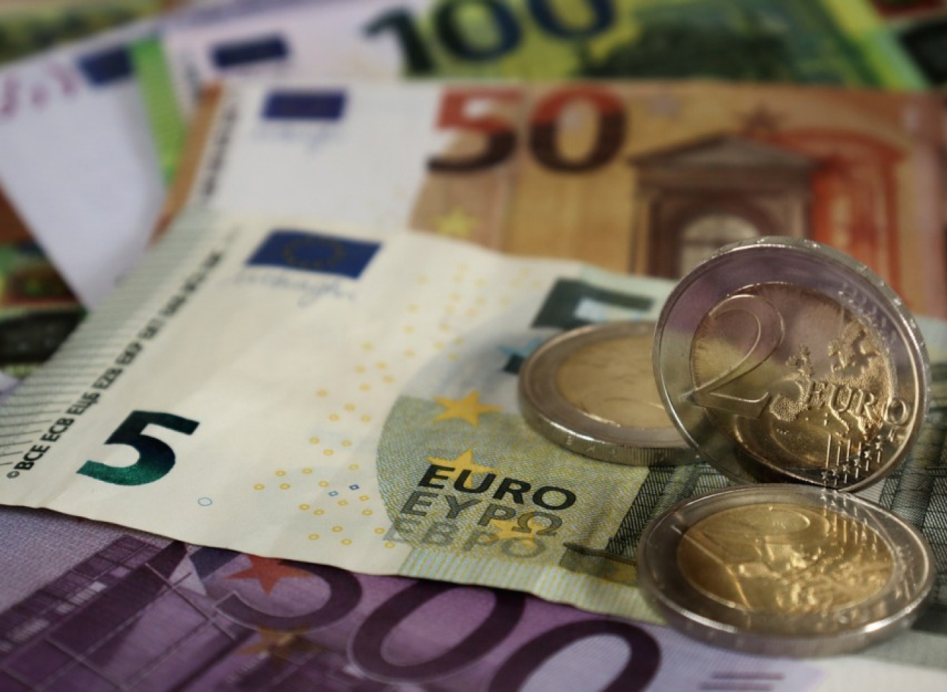 Asociatyvioje nuotraukoje - popieriniai eurų banknotai bei eurų monetos.